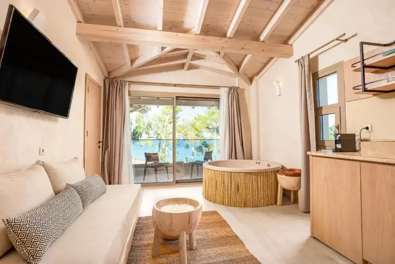 Espace de vie lumineux avec canapé, baignoire et kitchenette.