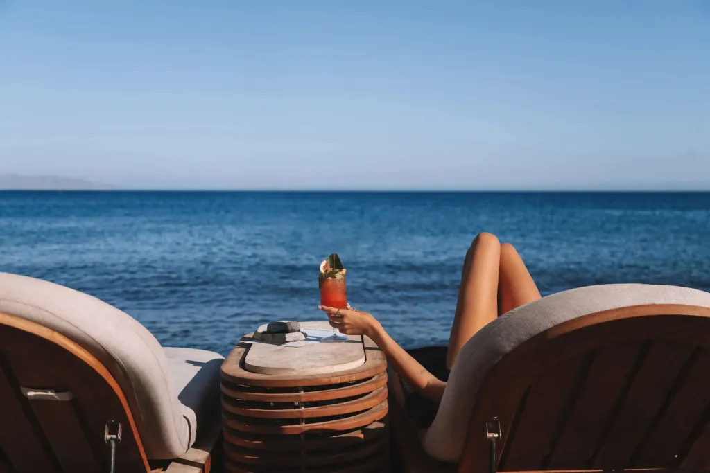 Deux transats face à la mer, un cocktail rafraîchissant à portée de main.