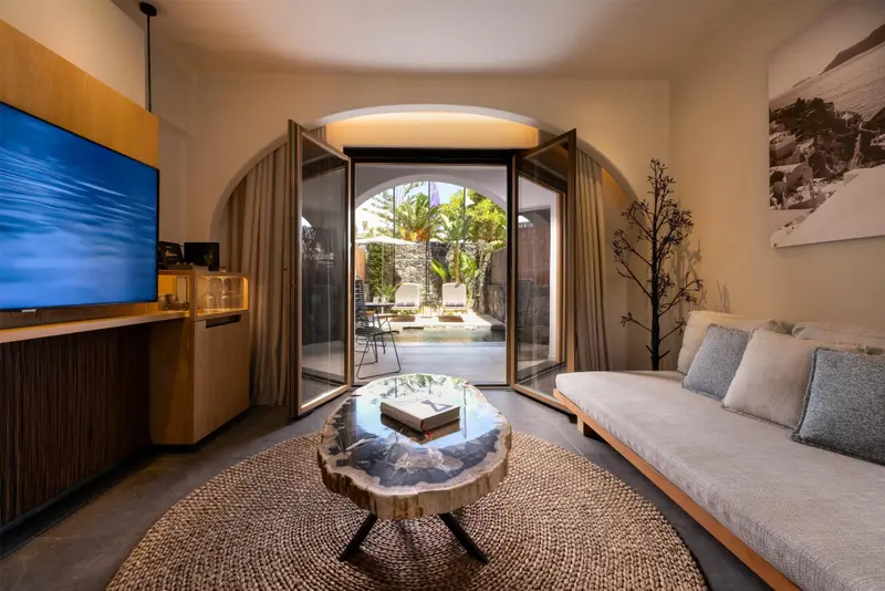 Un salon lumineux s'ouvre sur une terrasse avec piscine.
