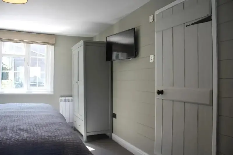 Une chambre lumineuse avec un lit et une armoire.