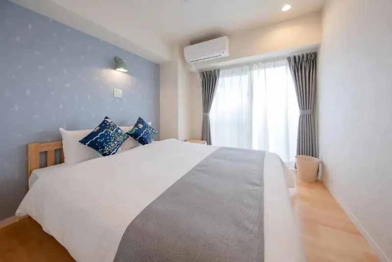 Une chambre lumineuse avec un grand lit et des oreillers décorés.
