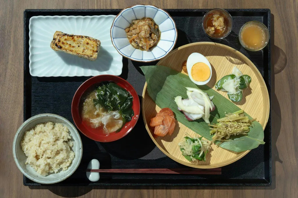Un plateau repas japonais avec divers plats et accompagnements.