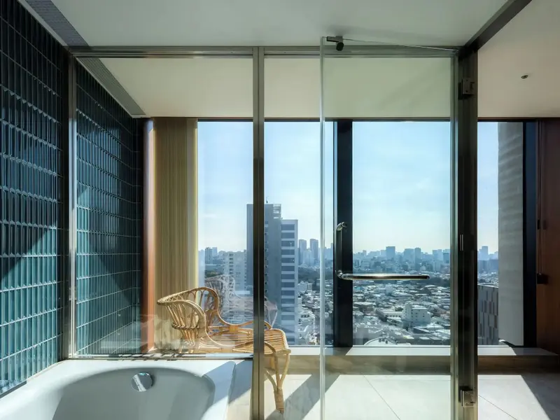 Une baignoire se trouve devant une grande fenêtre offrant une vue sur la ville.