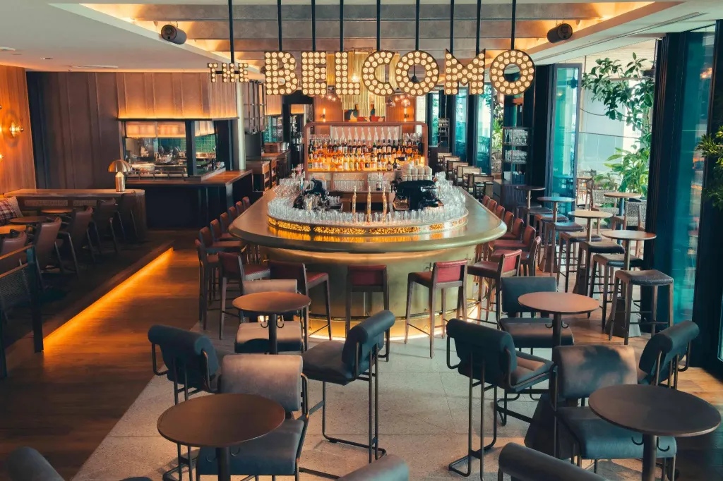 Un bar lumineux avec un comptoir incurvé et des tabourets.