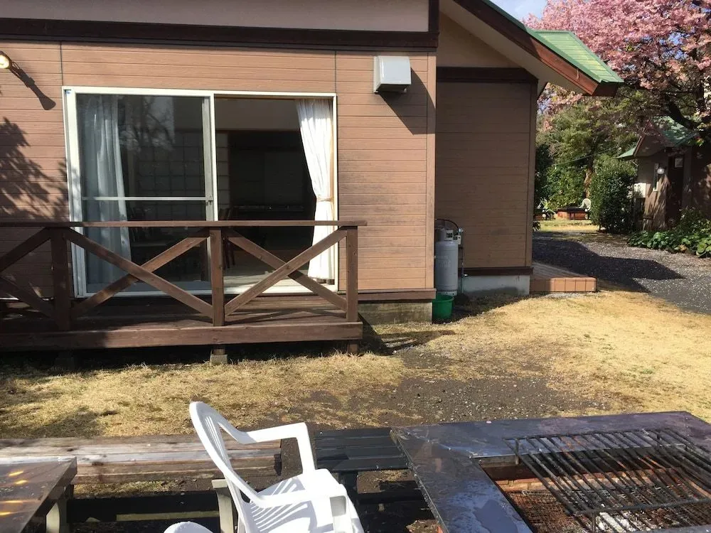 Une terrasse en bois donne sur un logement avec une baie vitrée.