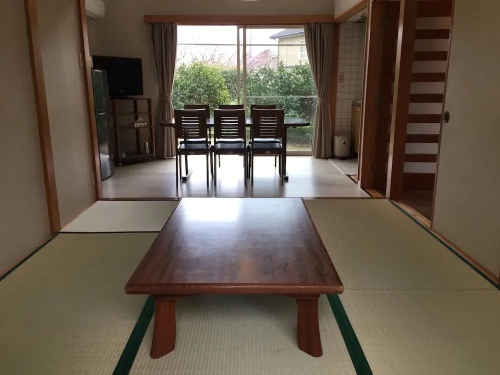 Une pièce lumineuse avec une table basse en bois et un sol recouvert de tatamis.