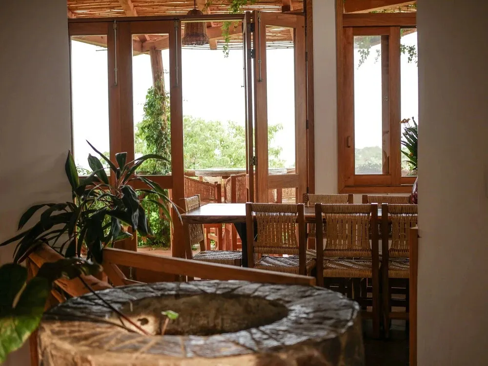 Une salle à manger lumineuse s'ouvre sur une vue verdoyante.