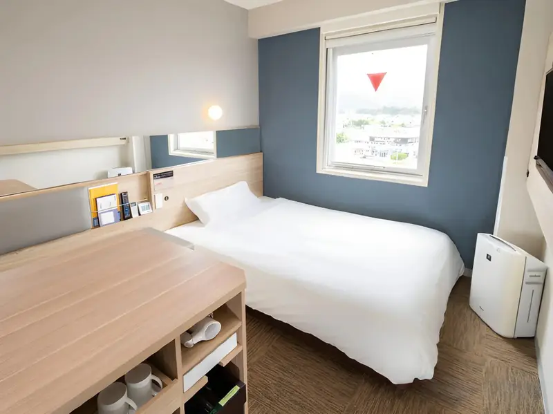 Une chambre lumineuse avec un lit simple et un bureau.