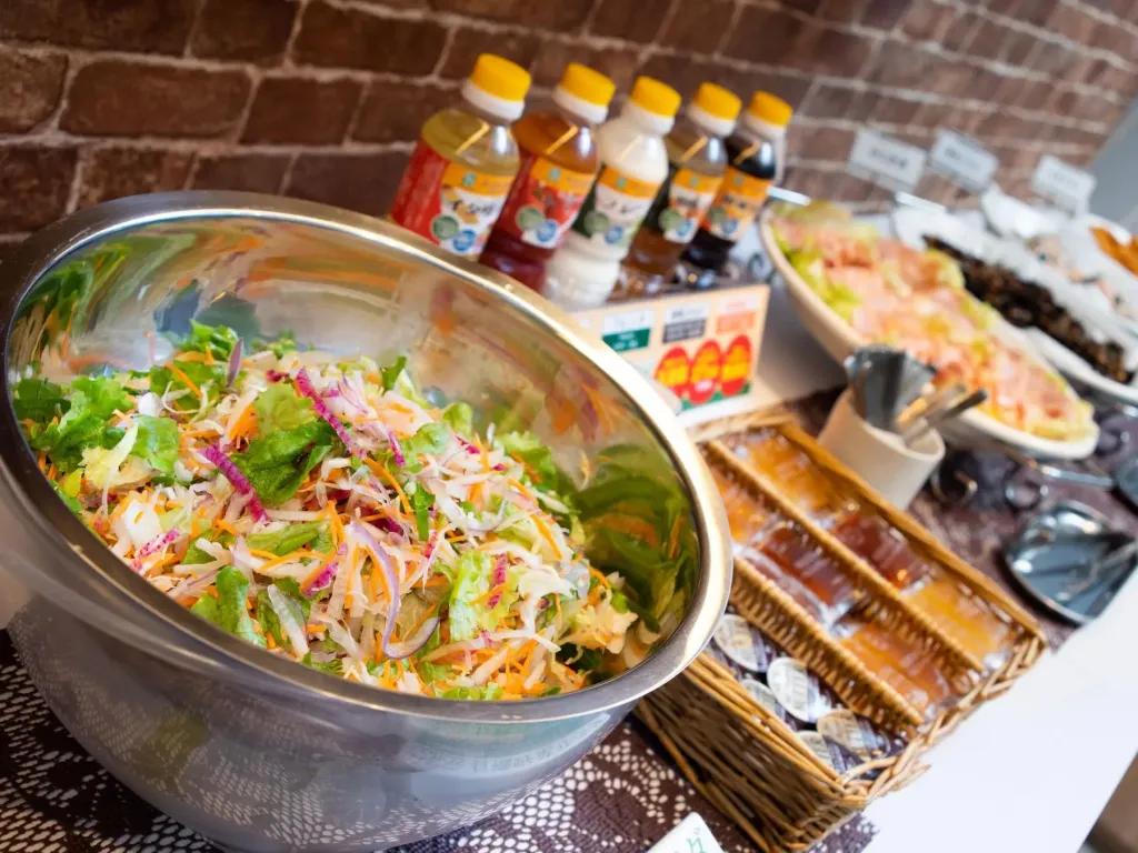 Salade fraîche et boissons disposées sur un buffet.