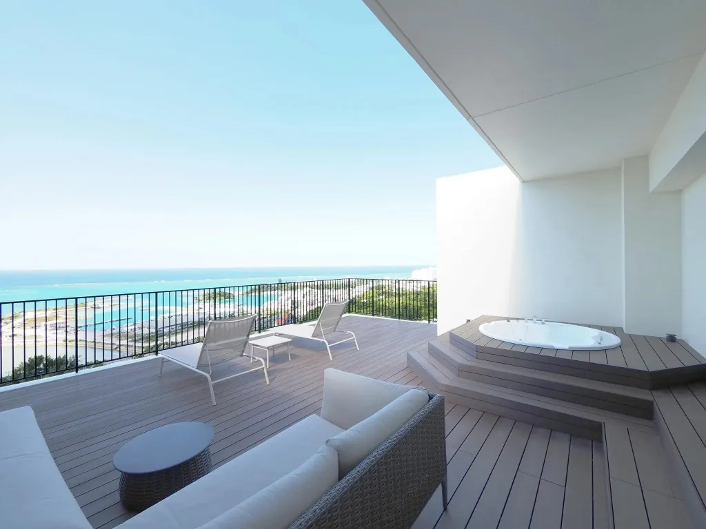 Terrasse aménagée avec salon et jacuzzi offrant une vue sur la mer.