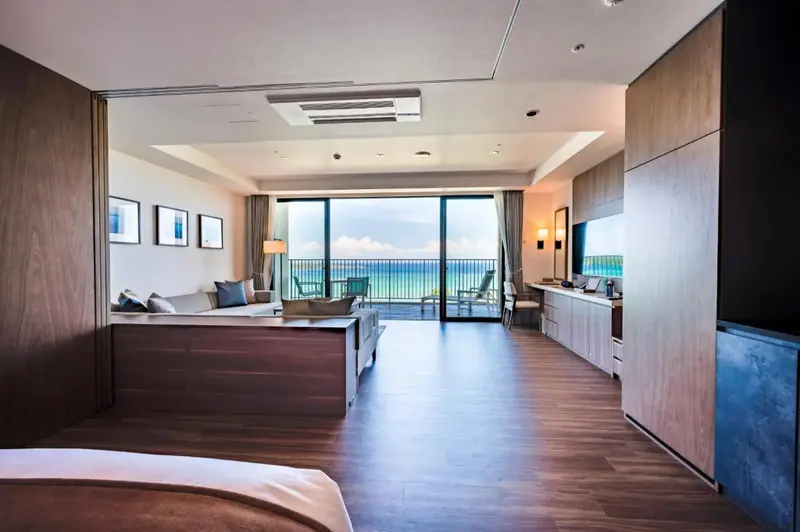 Espace de vie lumineux avec vue sur la mer depuis un balcon.