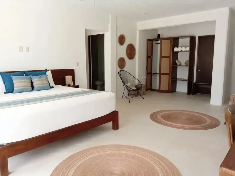Une chambre lumineuse avec un grand lit et une décoration sobre.