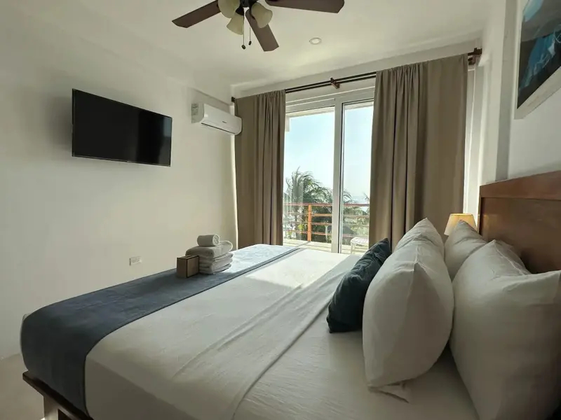 Une chambre lumineuse avec un grand lit et un accès à une terrasse.