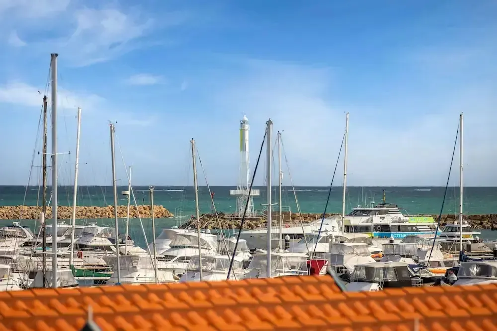 Un port de plaisance ensoleillé avec de nombreux bateaux à quai.