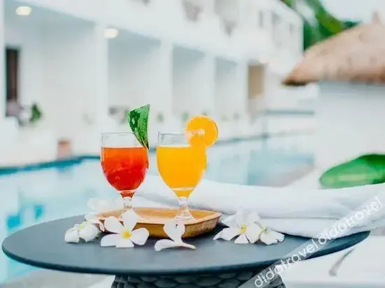 Deux boissons colorées sur une table basse près d'une piscine.