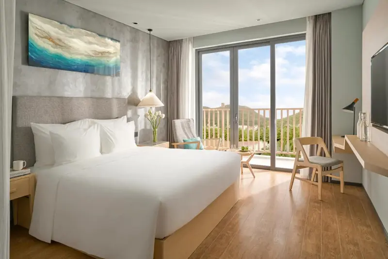 Une chambre lumineuse avec un grand lit et un accès à une terrasse.