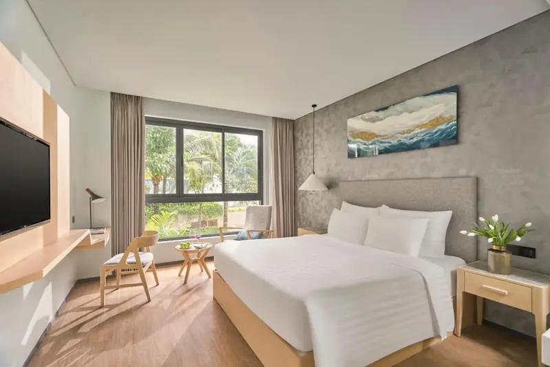 Une chambre lumineuse avec un grand lit et un bureau.
