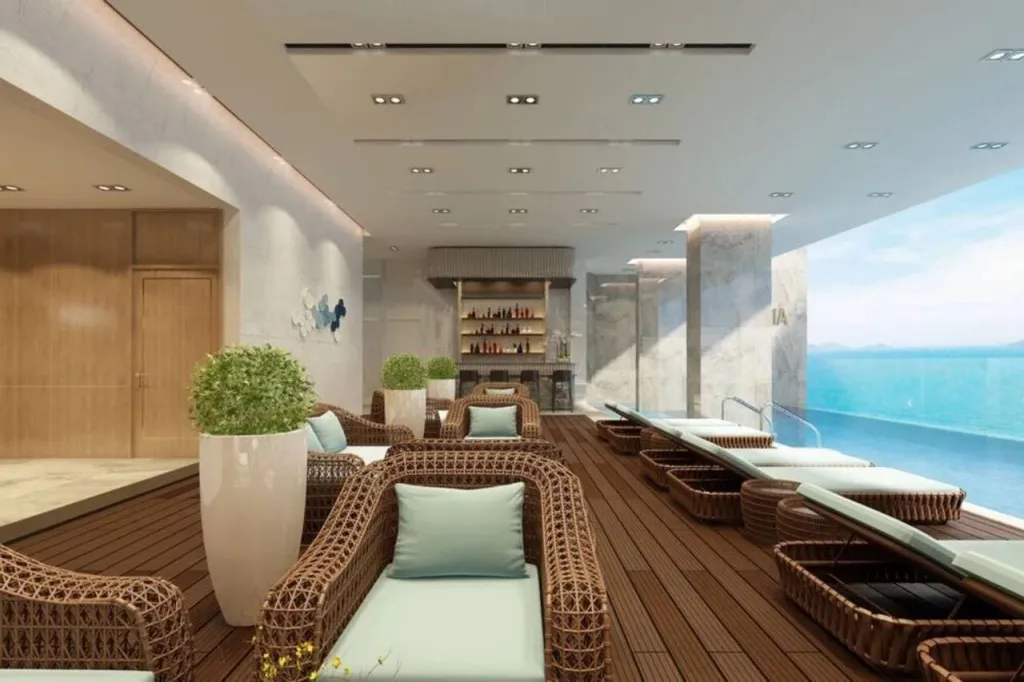Espace de détente extérieur avec mobilier en rotin et vue sur la mer.