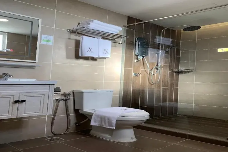 Une salle de bain carrelée avec douche et toilettes.