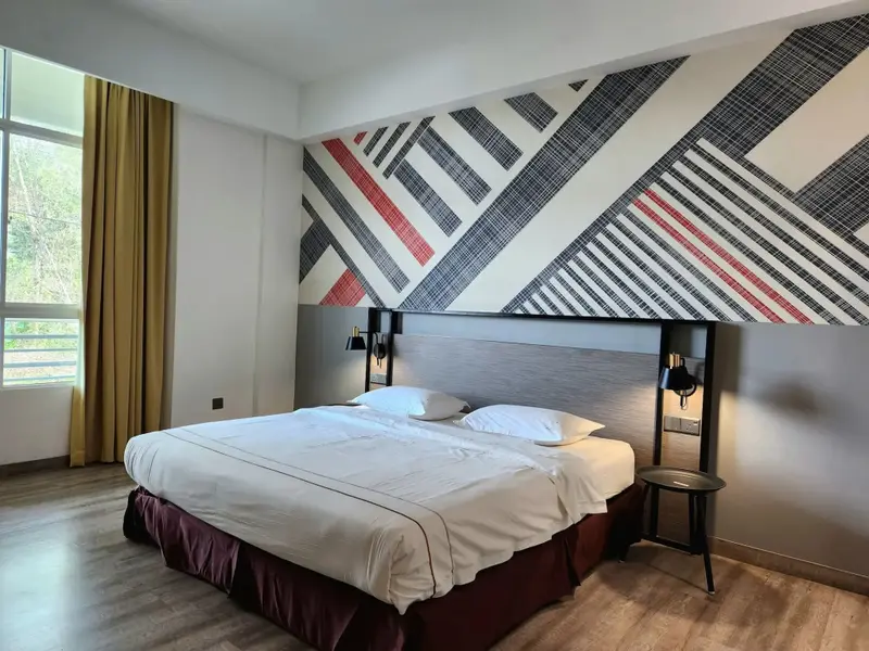 Une chambre lumineuse avec un grand lit et un mur décoratif.