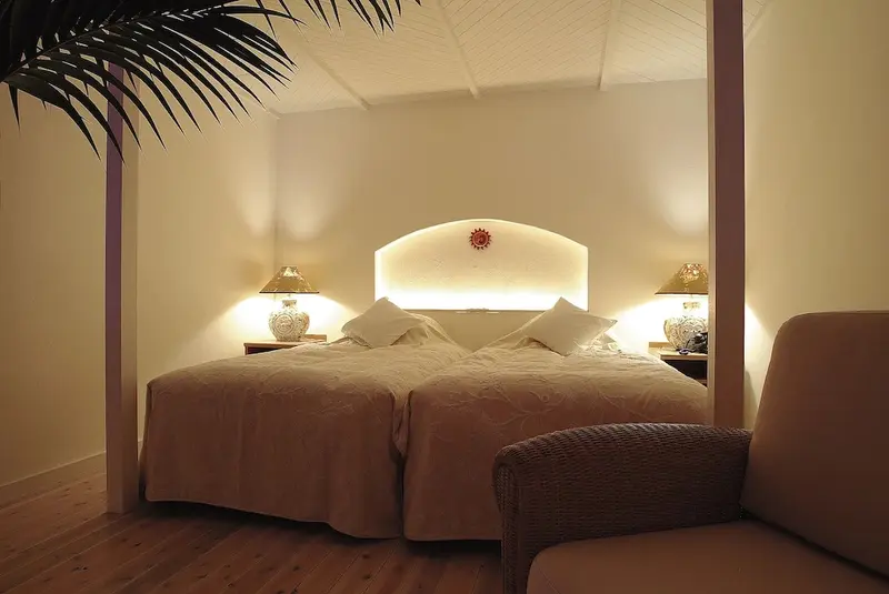 Une chambre lumineuse avec un grand lit et un fauteuil.