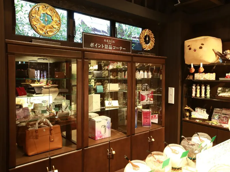 Présentation de produits dans des vitrines en bois, avec une décoration florale et des articles divers.
