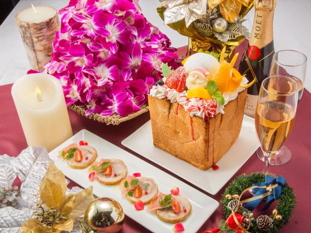 Nature morte festive avec un gâteau décoré, des amuse-gueules et des fleurs.
