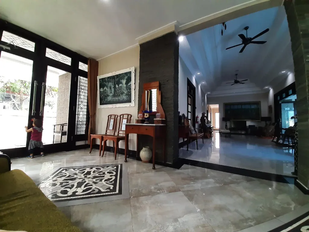 Vaste espace intérieur lumineux avec des meubles en bois et un tapis décoratif.