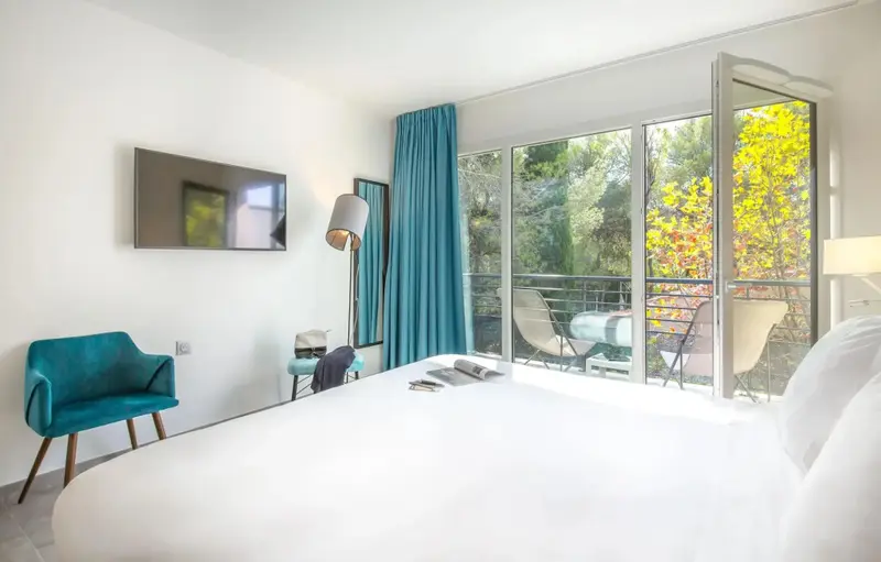 Une chambre lumineuse avec un grand lit et un accès à une terrasse.