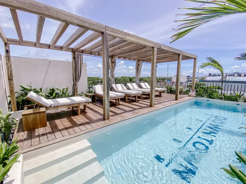 Terrasse avec transats et piscine ensoleillée.