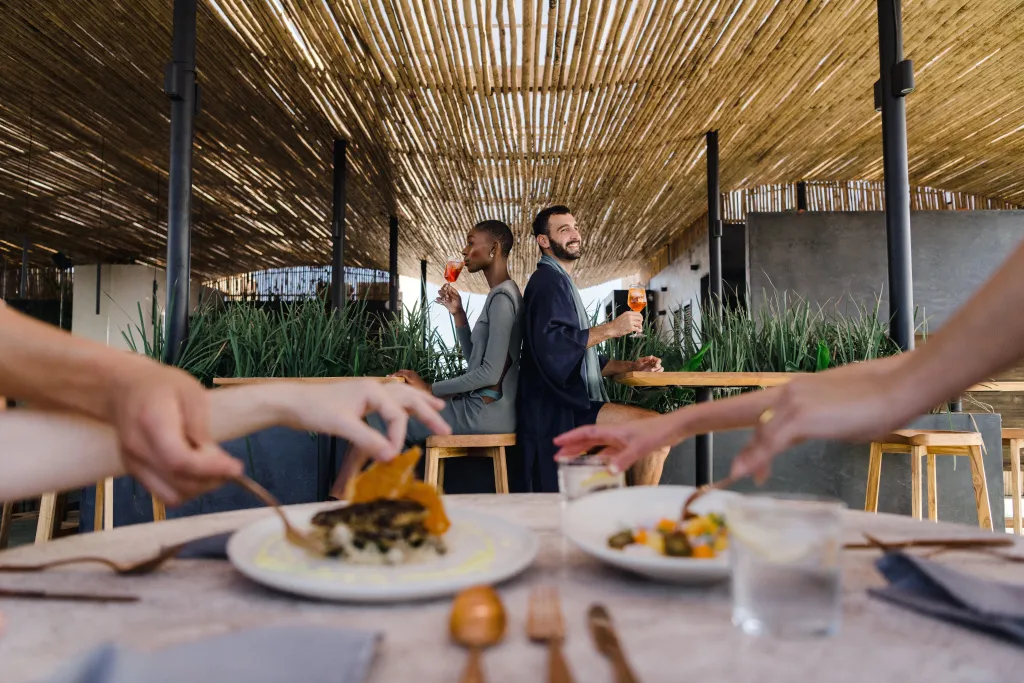 Une table est dressée avec des assiettes de nourriture, des couverts et des verres.