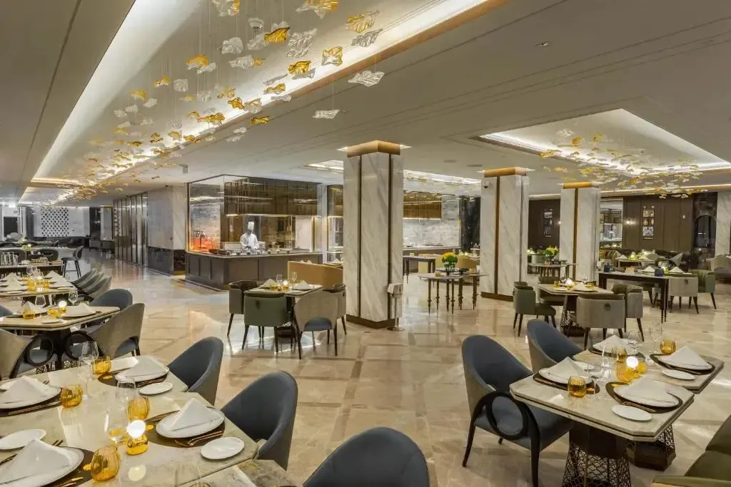 Une salle lumineuse avec des tables dressées pour un repas.