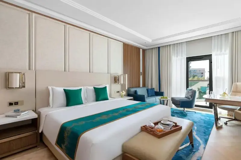 Une chambre lumineuse avec un grand lit et un coin salon.