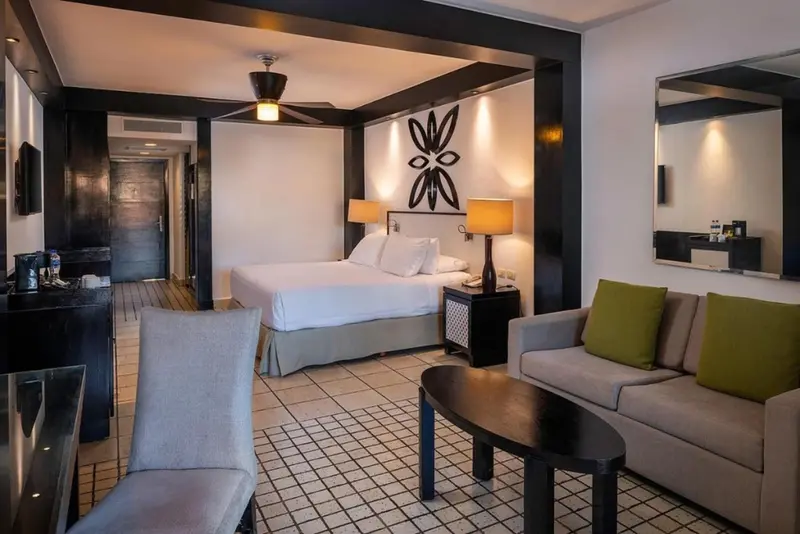 Une chambre lumineuse avec un coin salon et un lit king-size.
