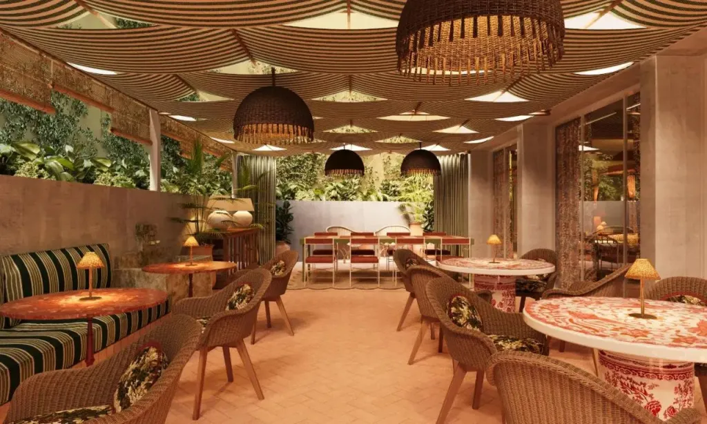 Une salle à manger lumineuse avec des tables rondes et des chaises en osier.